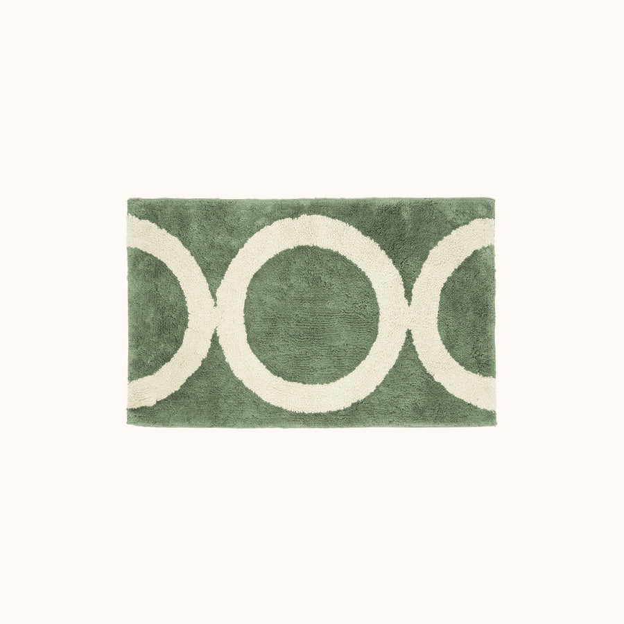 A green and beige geometric designed bath mat.
