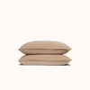 Two Dune / beige pillows stacked against a white background