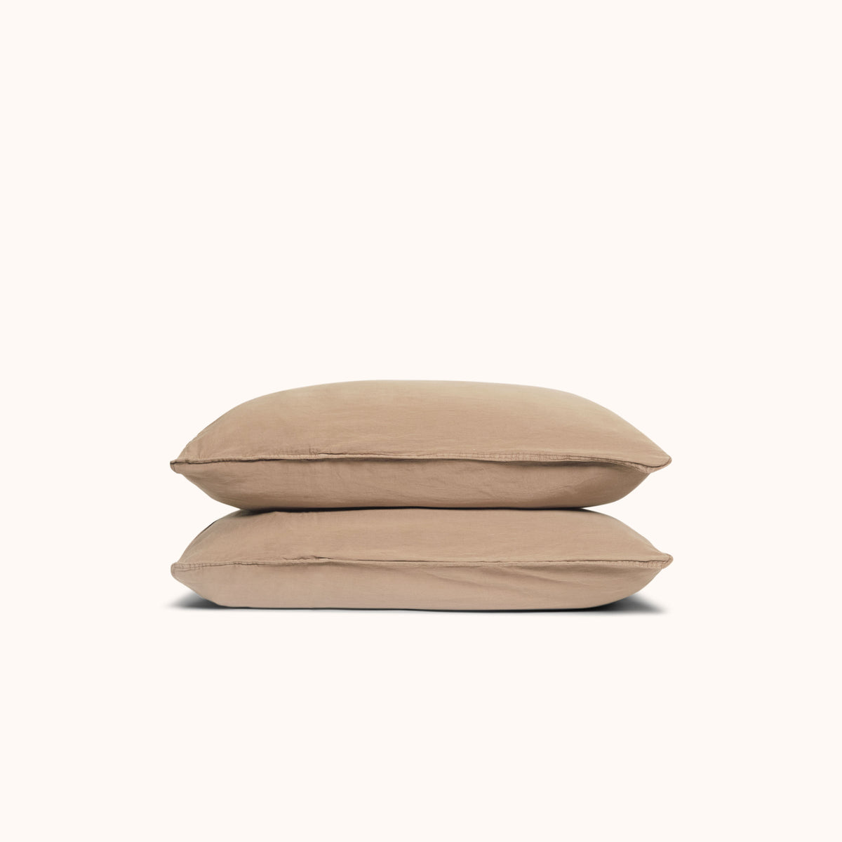 Two Dune / beige pillows stacked against a white background