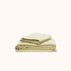 A sheet set in organic matte sateen Límon neatly stacked against a white background