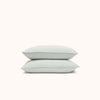 A set of stacked Mist / light blue matte sateen pillowcases against a white background.