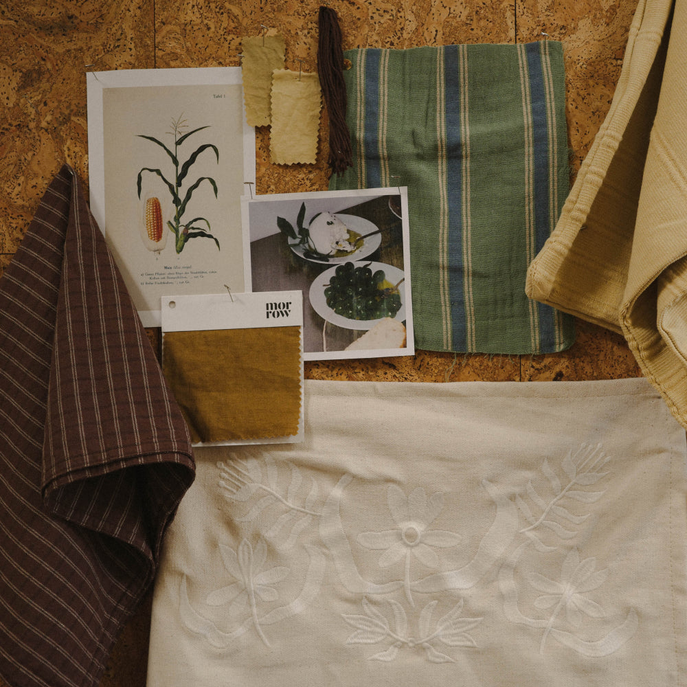 Textile samples and photos pinned to a cork board