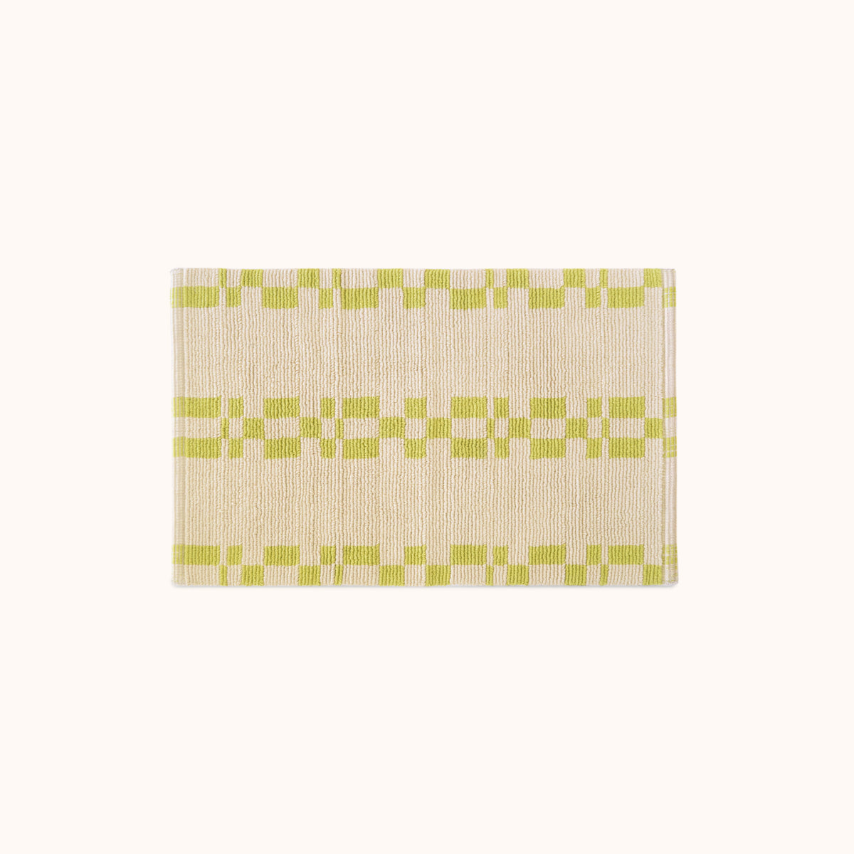 A rectangular, bathmat with a geometric pattern in green and beige colors.