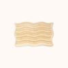Rectangular bath mat with wavy pattern and alternating shag heights on a white background