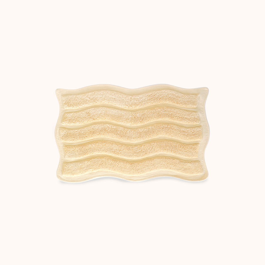 Rectangular bath mat with wavy pattern and alternating shag heights on a white background