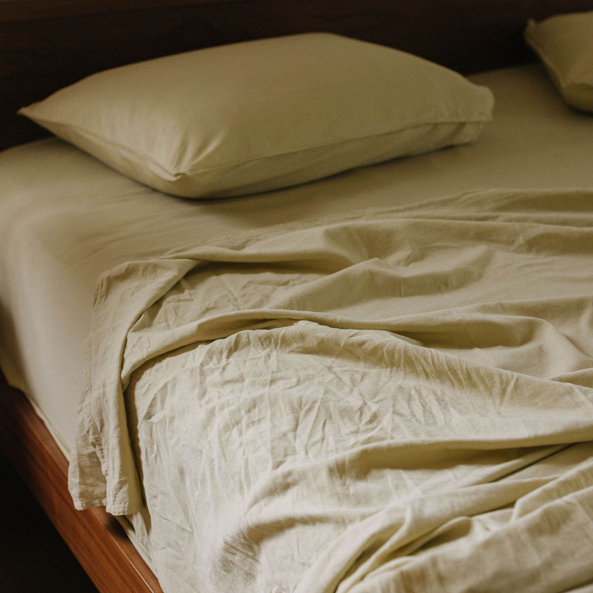 A close up of a bed dressed in Límon / light yellow matte sateen sheets