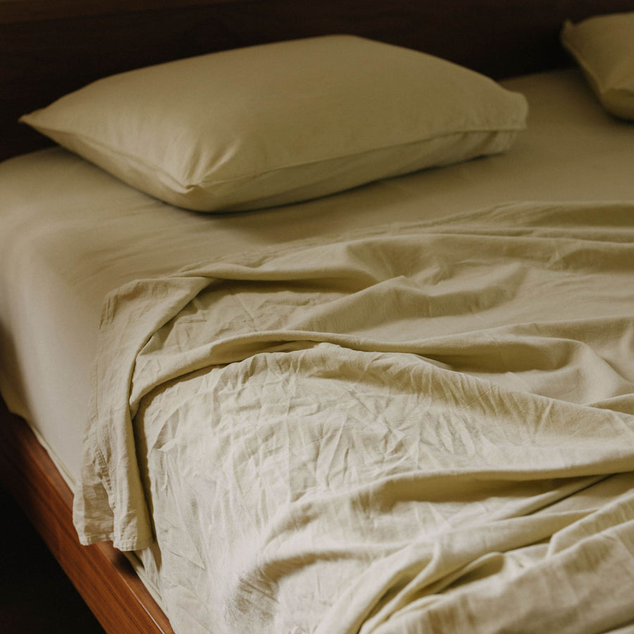 A close up of a bed dressed in Límon / light yellow matte sateen sheets