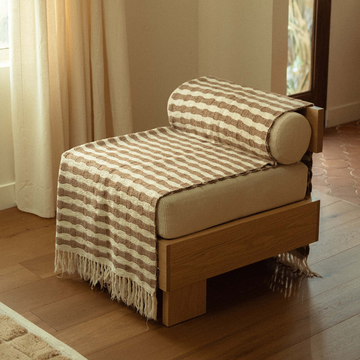 The Ramona folded neatly on a modern accent chair in a living room setting