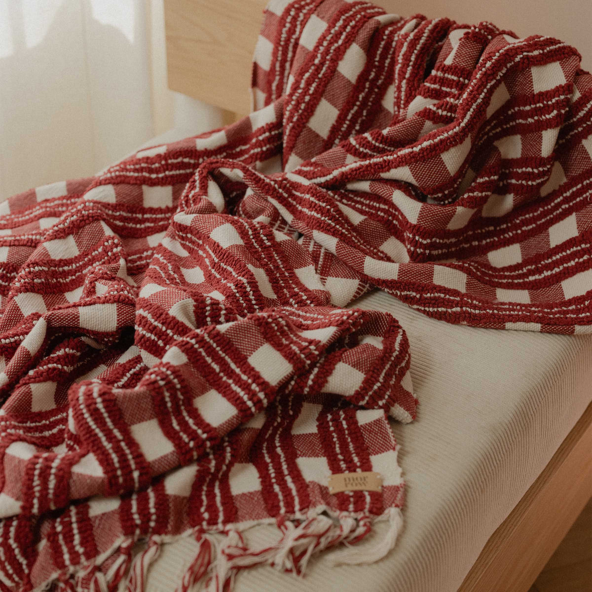 Red and cream pattern blanket on a chair.