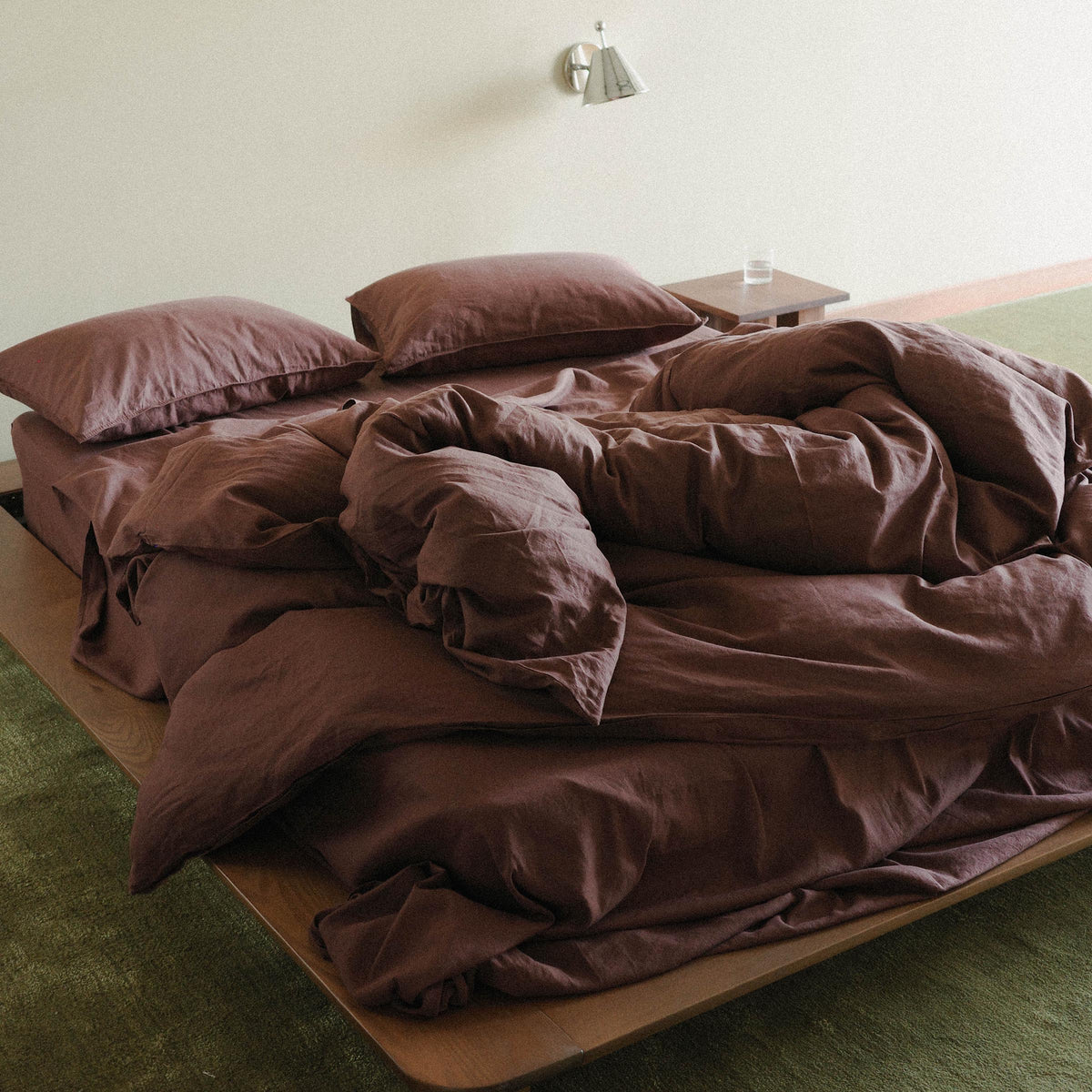 Brown duvet cover and pillows on a bed in a minimalist room