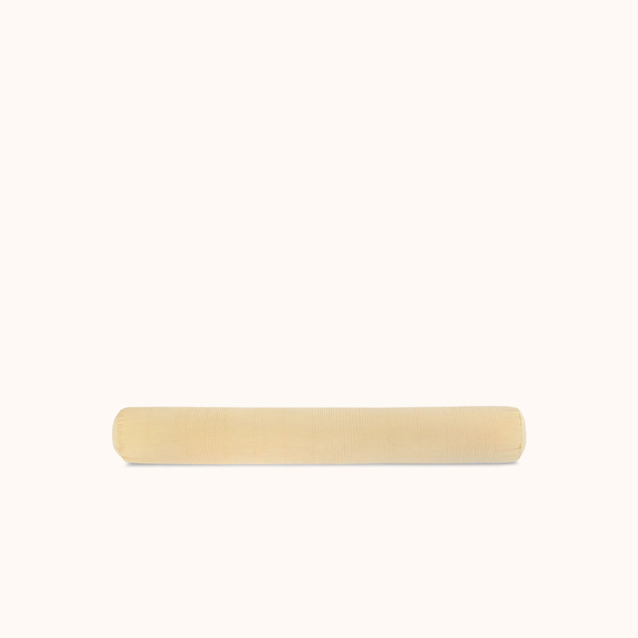Long bolster pillow in a beige / yellow color against a white background