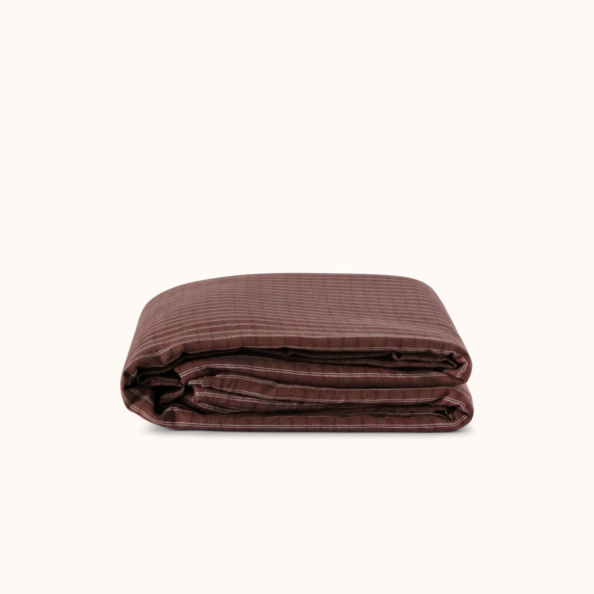 Folded brown striped duvet cover against a white background