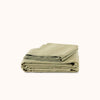 Folded green striped sheet set on a white background