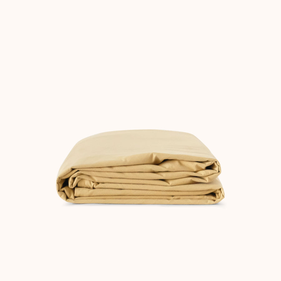 Yellow folded duvet cover on a white background
