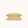 Two yellow pillows stacked on a white background
