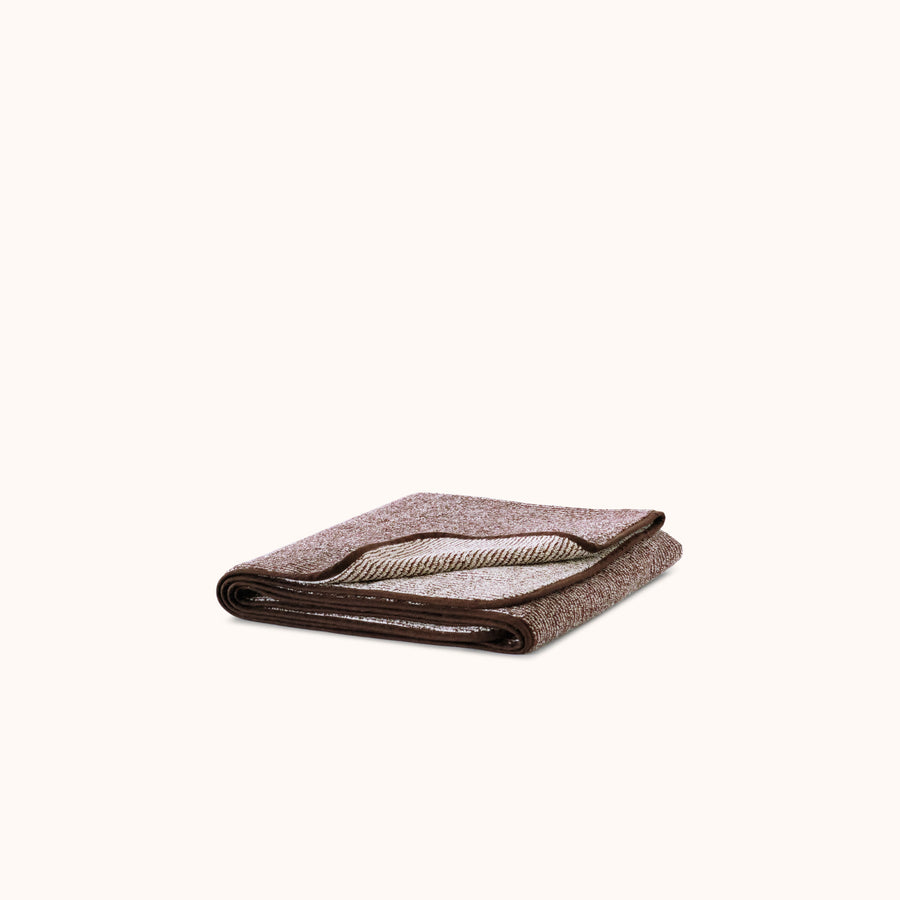 Folded striped terry bath towel in brown and ecru color, with a soft textured surface.