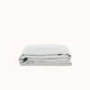 A folded pale blue / Mist fitted sheet made of organic cotton, displayed on a white background.