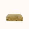 Folded green coverlet on a white background