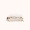 A folded cream colored duvet cover against a white background