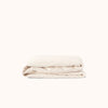 Cream fitted sheet folded on a white background