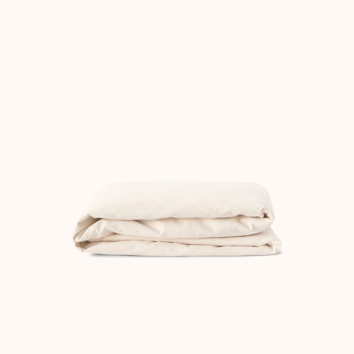 Cream fitted sheet folded on a white background