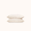 Two cream pillows stacked on a white background
