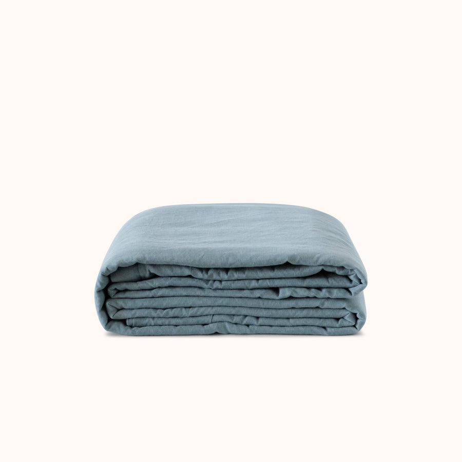 Folded duvet cover in a deep blue color, showcasing its texture and material.
