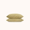 Two green pillows stacked on a white background