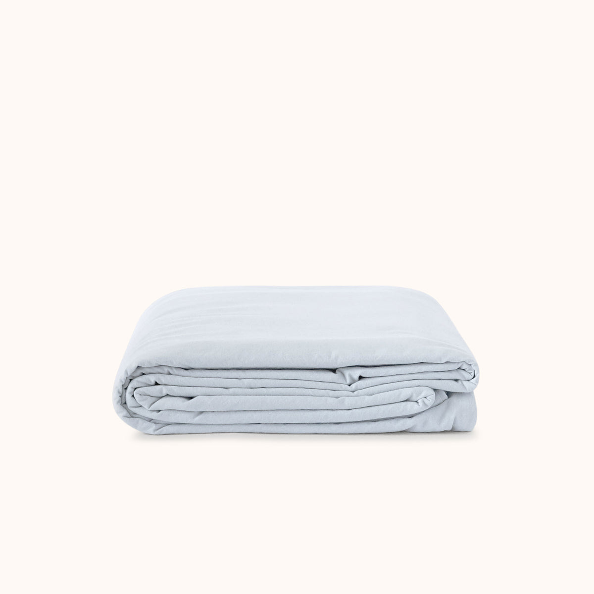 Folded light blue duvet cover on a white background