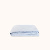 Light blue folded fitted sheet on a white background