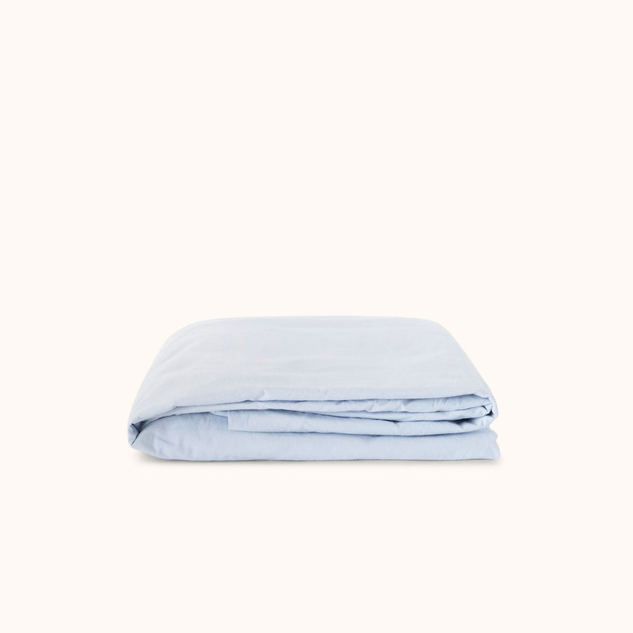 Light blue folded fitted sheet on a white background