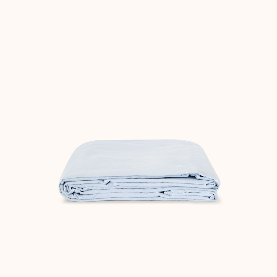 Folded light blue flat sheet on a white background