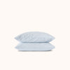Two light blue pillows stacked on a white background