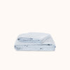 Folded light blue sheet set on a white background