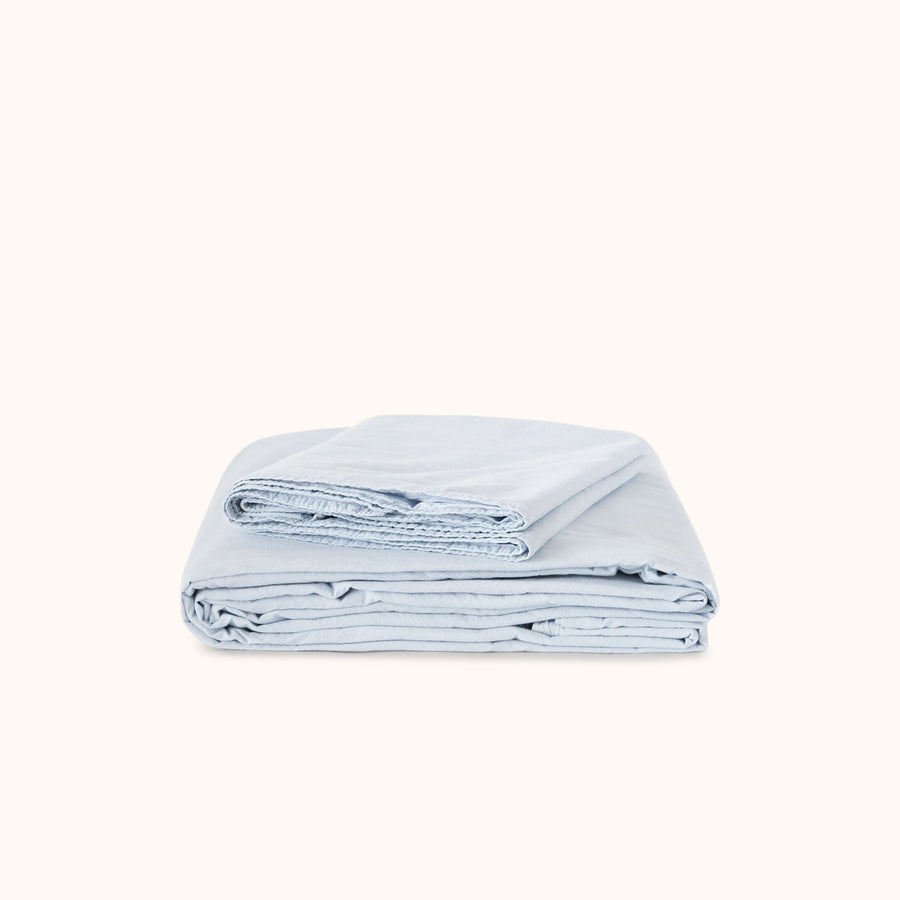 Folded light blue sheet set on a white background