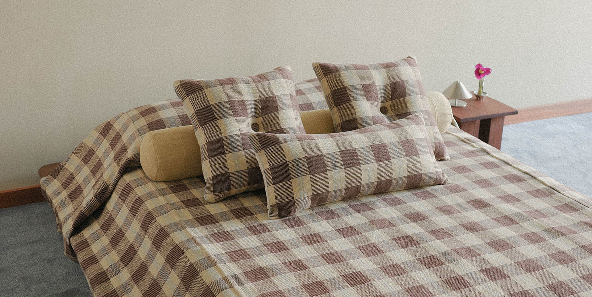 Bed with plaid bedding and pillows in a bedroom setting