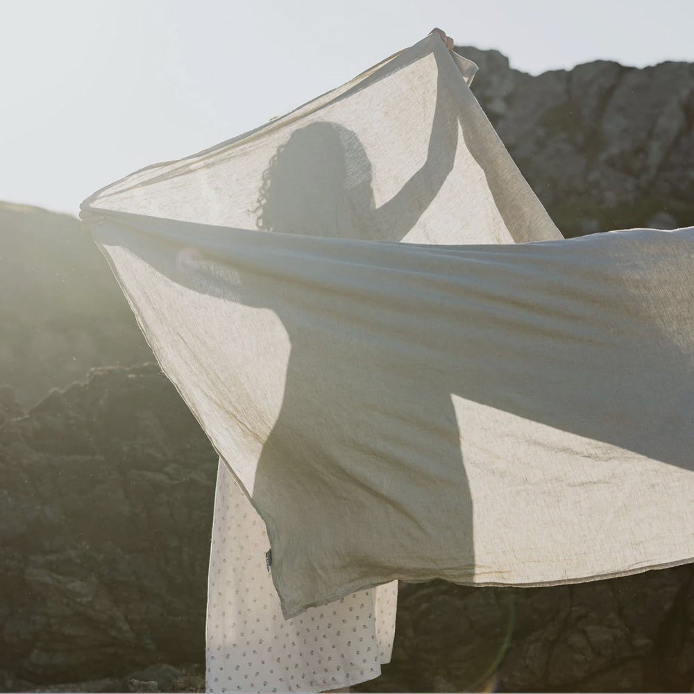 Shadow of a woman holding a sheet in the sun