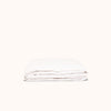 A folded white matte sateen fitted sheet against a white background.