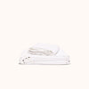 A folded white organic matte sateen sheet set against a white background